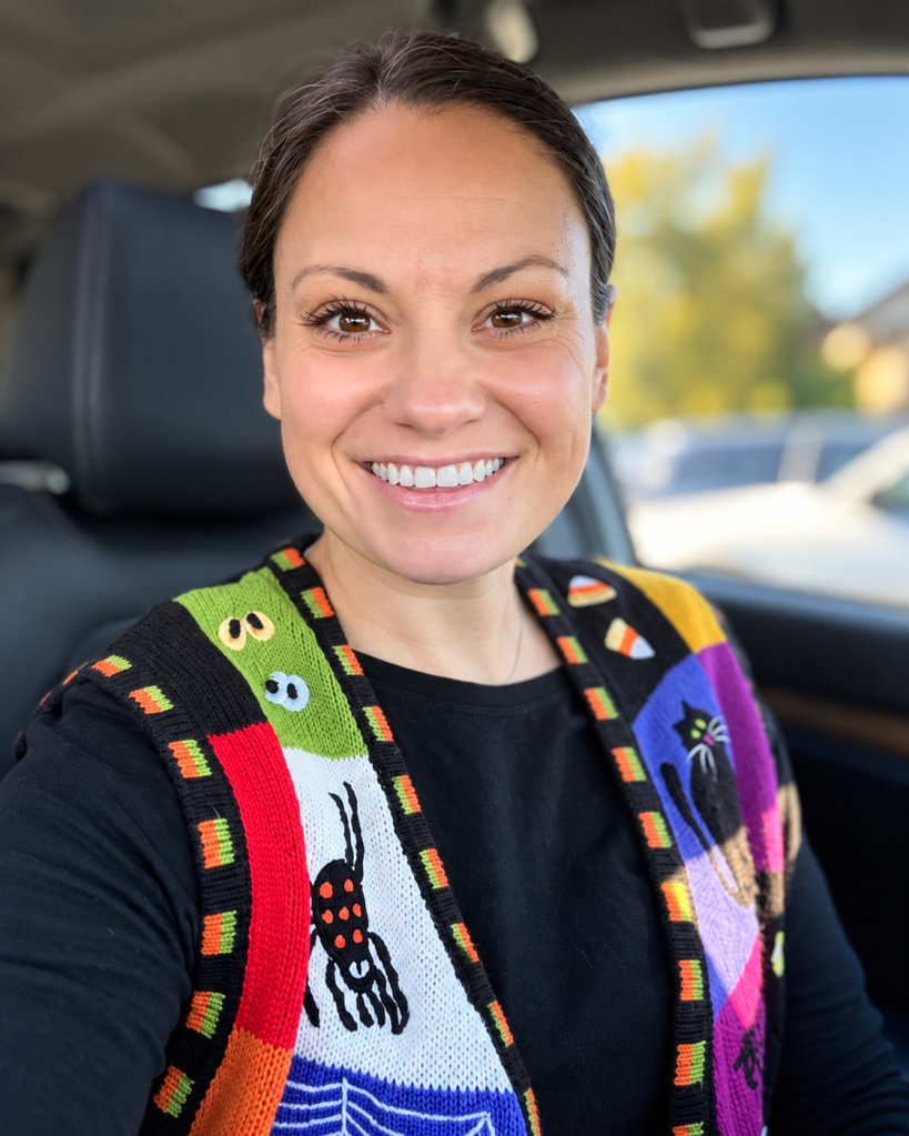 Ashton smiling in her colorful Halloween knit vest